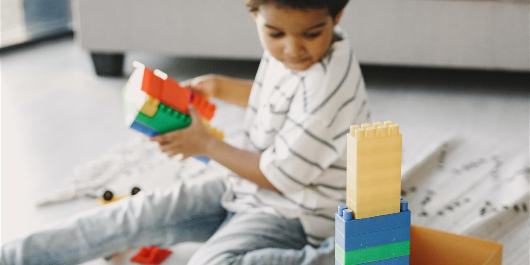 A child playing with colourful plastic building bricks