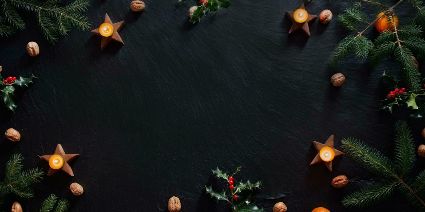 Candles and Christmas decorations on slate background