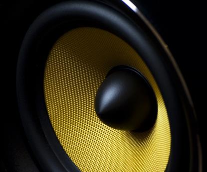 Zoomed in shot of a black speaker with bright yellow mesh
