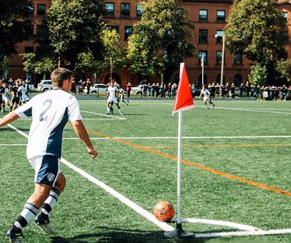 Man playing in a football match doing a corner kick