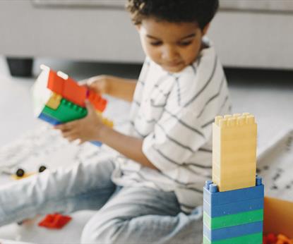 A child playing with colourful plastic building bricks