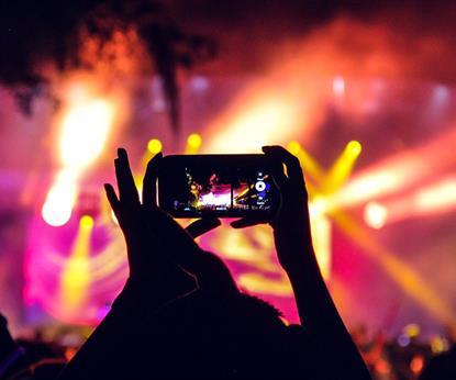 People at a concert taking pictures with phones