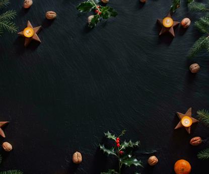 Candles and Christmas decorations on slate background