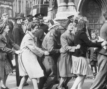 A photo from VE day in Leicester with people dancing round the clock tower