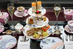 An afternoon tea with cakes and flowery pink tea set