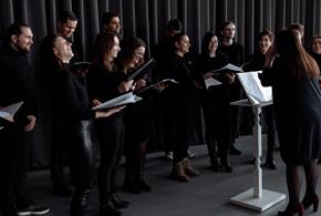 Group of people in black outfits about to sing