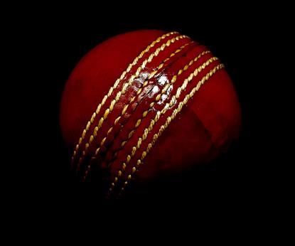 Red cricket ball on dark background