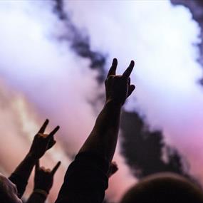 Hands in the air with pink and purple smoke