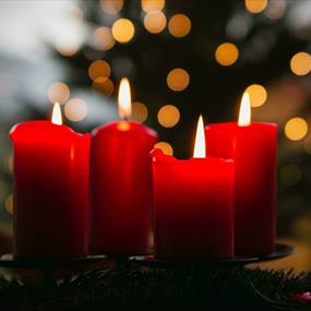 Red candles lit on a Christmas display