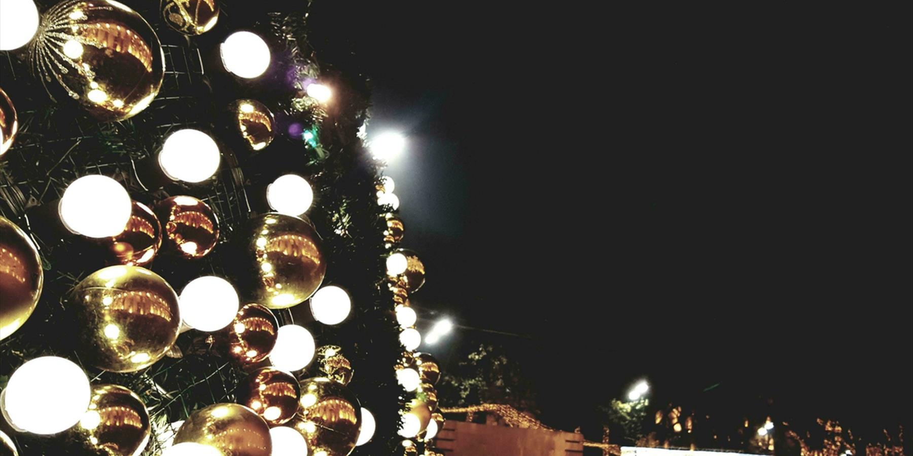 Gold and silver baubles displayed on the wall of an outdoor display