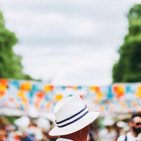 Person in white hat in front of blue and orange bunting