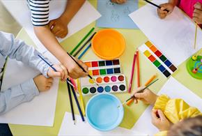 Children using pencils paint and colourful paint
