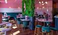 Inside of Audrey bar with pink walls and green space