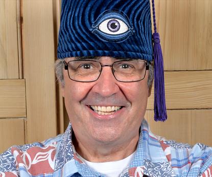 A man wearing a blue hat with an eye on the front
