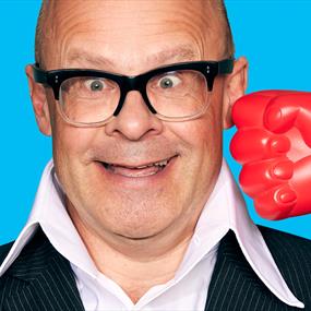 Man smiles comically while a joke toy boxing glove is pointed at his face