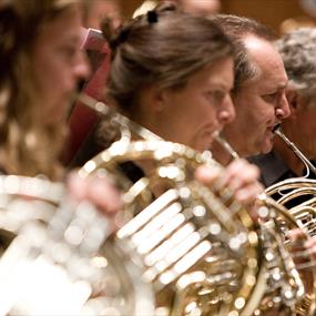 Members of an orchestra playing horns