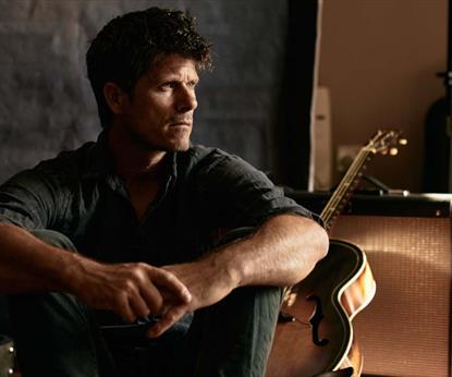Seth Lakeman in front of guitars