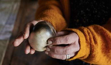 Pair of hands holding a ball of clay