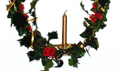 Advent candle decorated with festive foliage