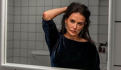Demi Moore studies her reflection in The Substance