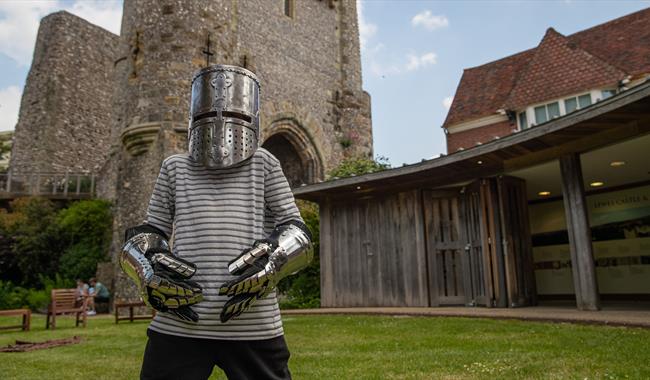Young visitor wearing armour at Lewes Castle