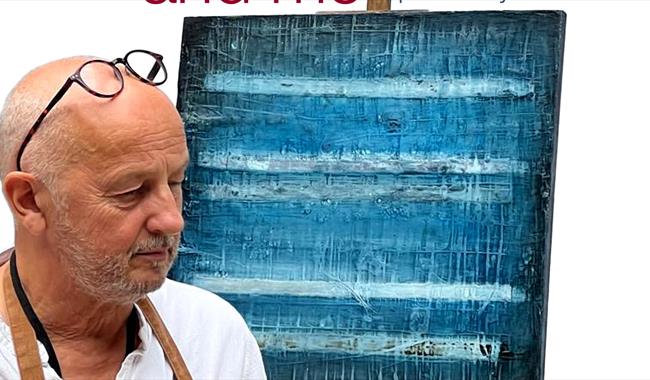 Artist and writer John Worth with artwork on an easel.