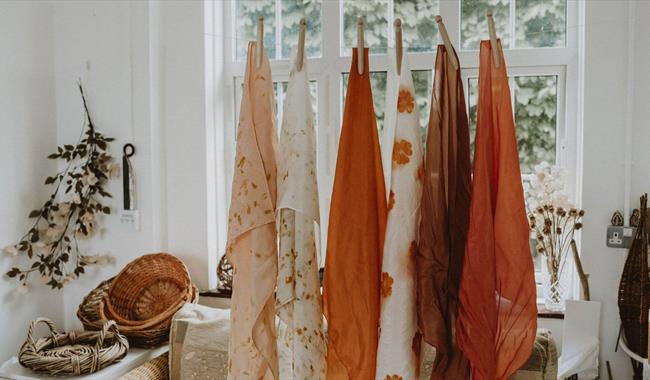 dyed fabrics hanging in a window