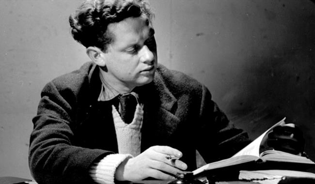 Black and white image of writer with cigarette at his desk