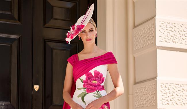 Woman dressed in elegant pink and white hat and dress