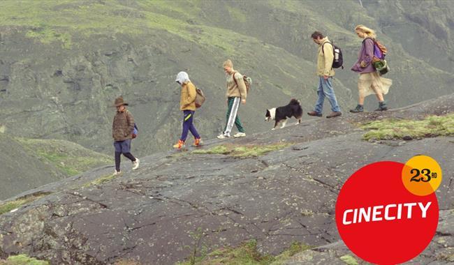 people with dog walking across a Downs landscape