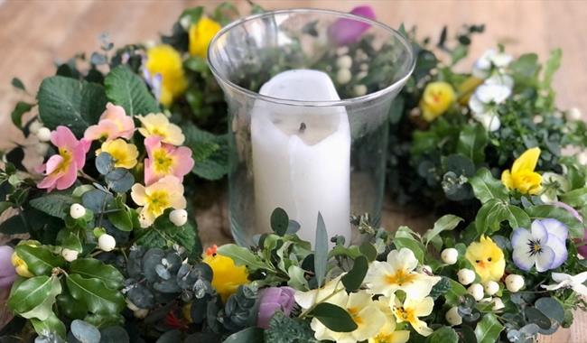 Wreath featuring spring flowers around a candle