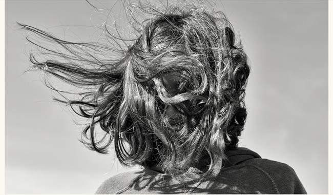 A figure's hair blowing in the breeze