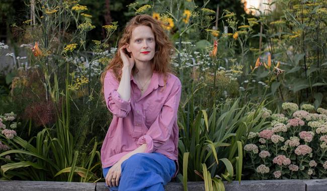 Writer Charlotte Cray seated in a garden
