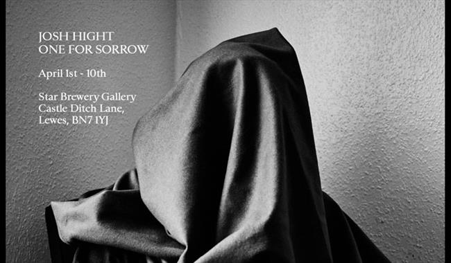 black and white photograph of hooded figure
