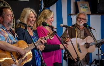 Folk group sing Shake Me Up Sally