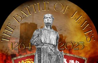 Statue with shields standing against a silhouette of Lewes Castle