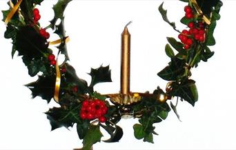 Advent candle decorated with festive foliage
