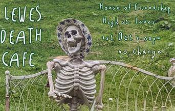 Skeleton wearing a hat sitting on a garden bench.