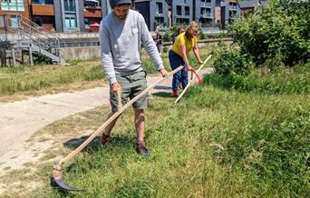 Man using a scythe on the Railwayland