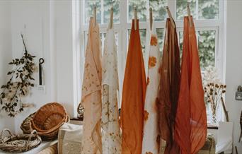 dyed fabrics hanging in a window