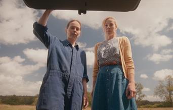 2 women looking into a car boot