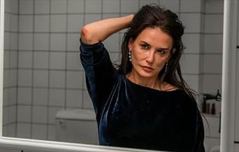 Demi Moore studies her reflection in The Substance