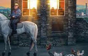 Man on a horse in front of a building