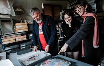 People discussing a range of paintings and documents
