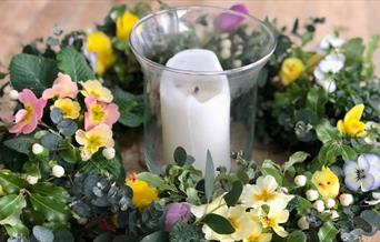 Wreath featuring spring flowers around a candle