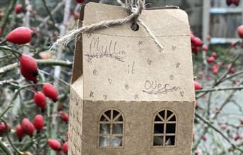 Cardboard house shaped box of tea bags with winter berries