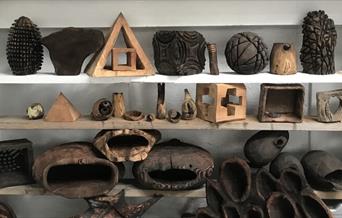 Wooden sculptures and objects on shelves