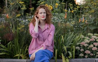 Writer Charlotte Cray seated in a garden
