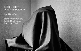 black and white photograph of hooded figure