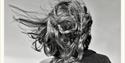 A figure's hair blowing in the breeze